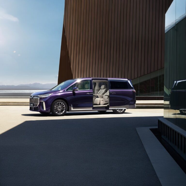 Purple Voyah Dream with open sliding door against modern architectural building