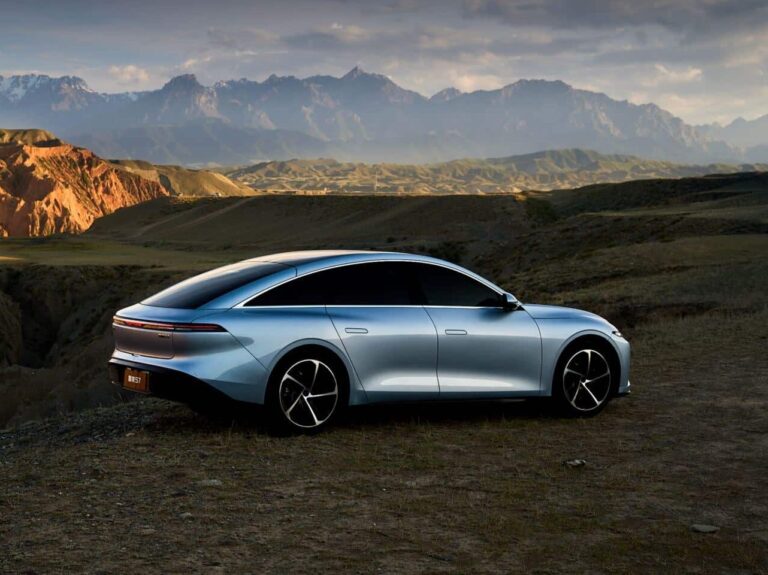 Elegants Forthing S7 elektroauto ar panorāmas jumtu kalnu ainavu fonā saulrietā