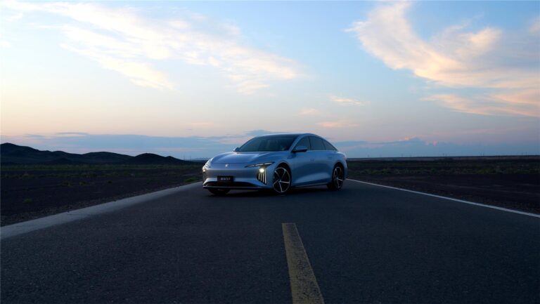 Forthing S7 electric cars against the backdrop of wind turbines and ocean — a combination of style and sustainable technologies